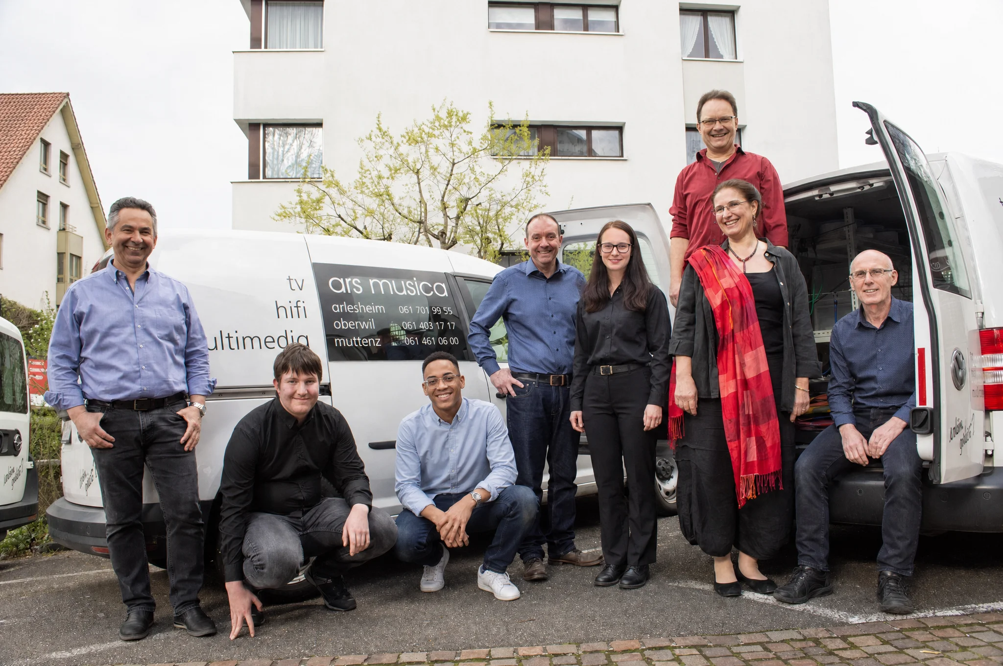 Das Team von ars musica vor den Servicefahrzeugen
